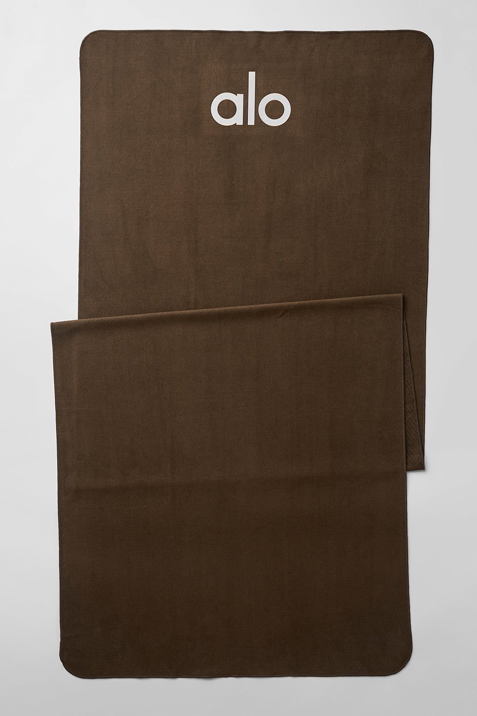 Grounded yoga towel in use during hot yoga session with visible sweat absorption