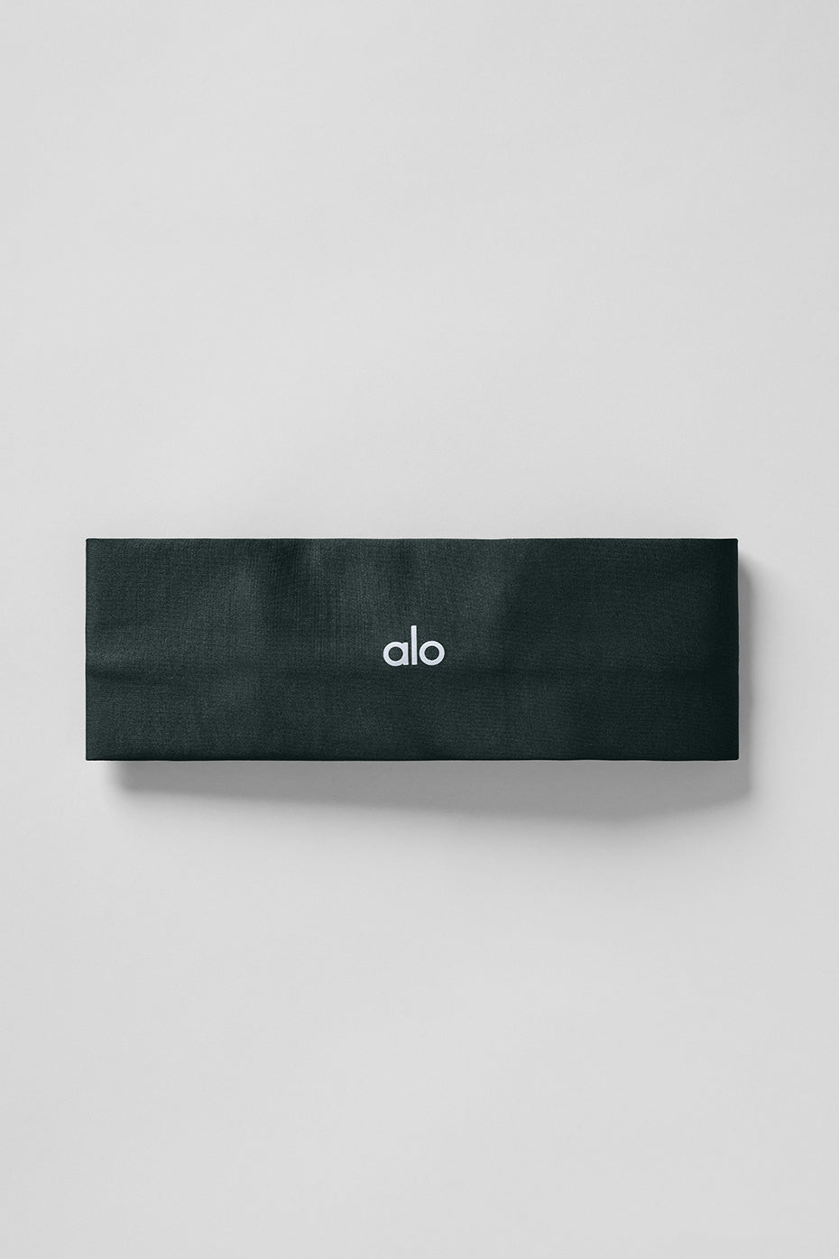 Charcoal green headband folded, displaying its lightweight texture.