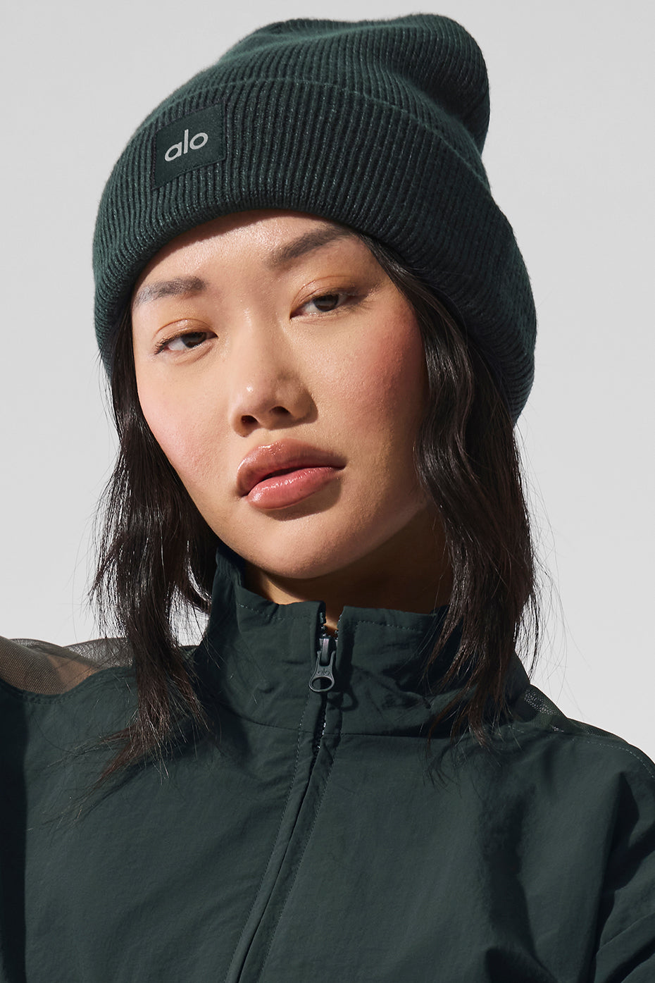 Charcoal green wool blend beanie worn outdoors in winter.