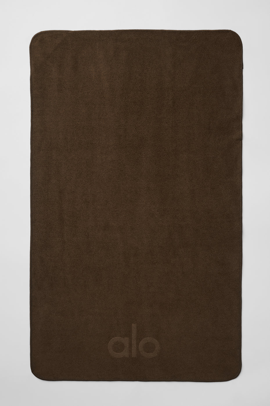 Microfiber yoga towel folded on a mat in natural light