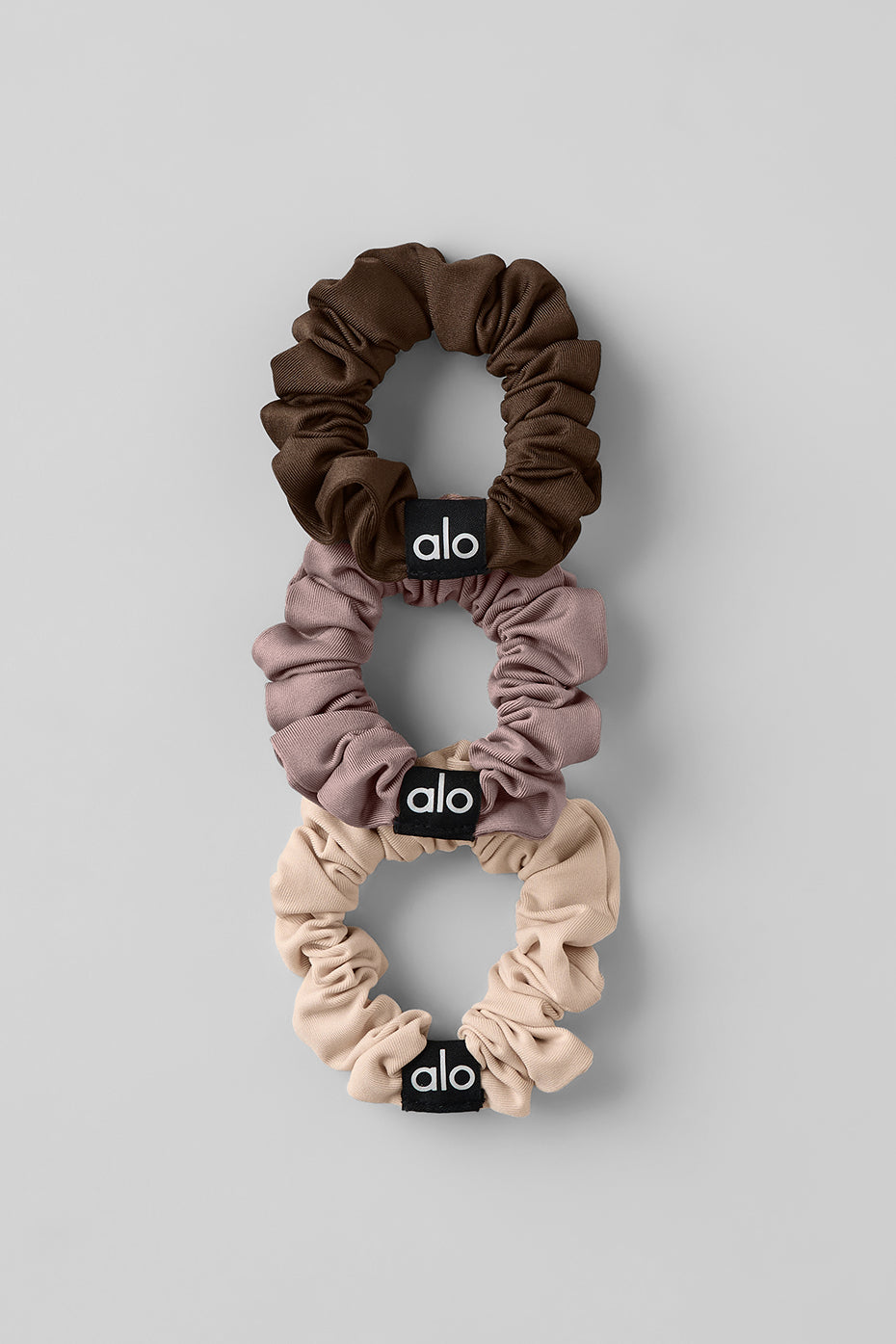 Chic mini scrunchie trio in macadamia, taupe, and espresso colors for fashionable hairstyles.