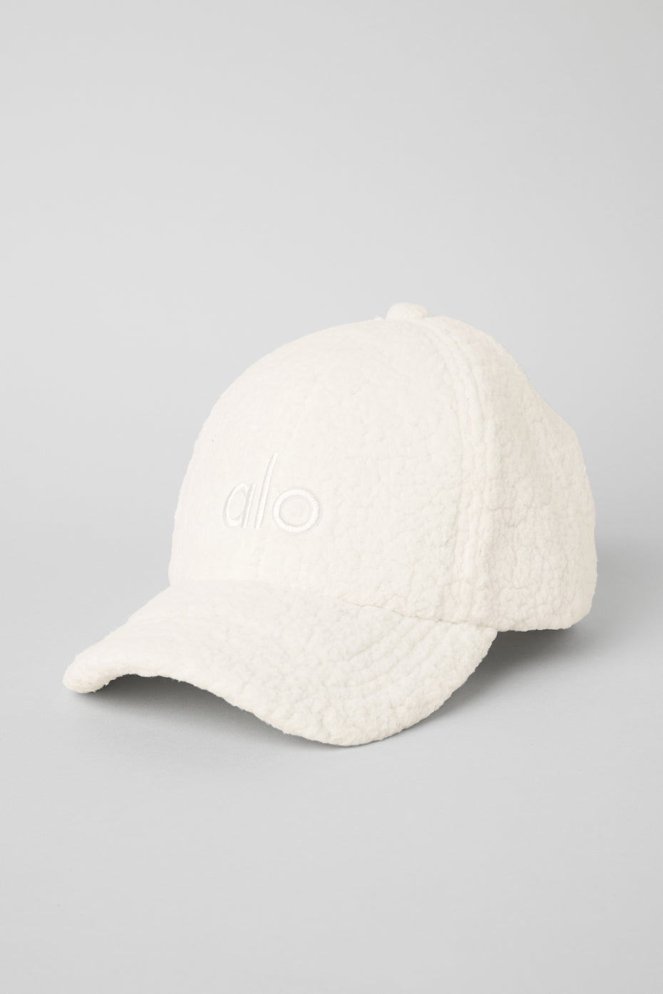 Front view of ivory sherpa dad hat with embroidered logo.