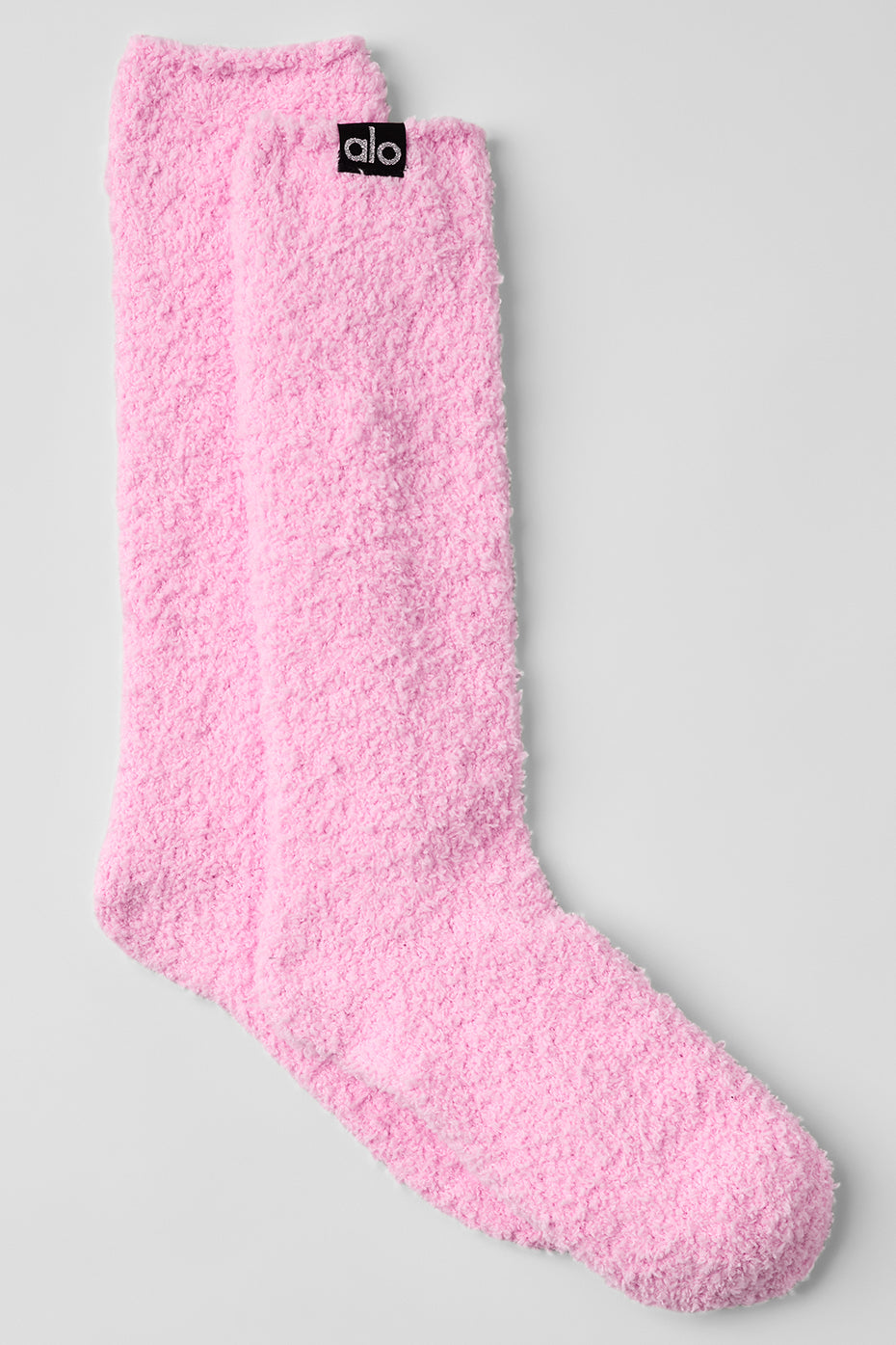 Women's ankle socks in soft pink, styled on a wooden floor