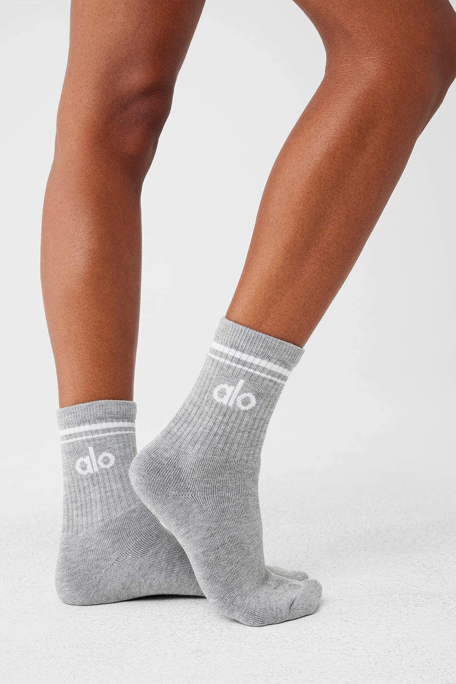 Full-length image of white crew socks styled with womens sneakers and shorts outdoors