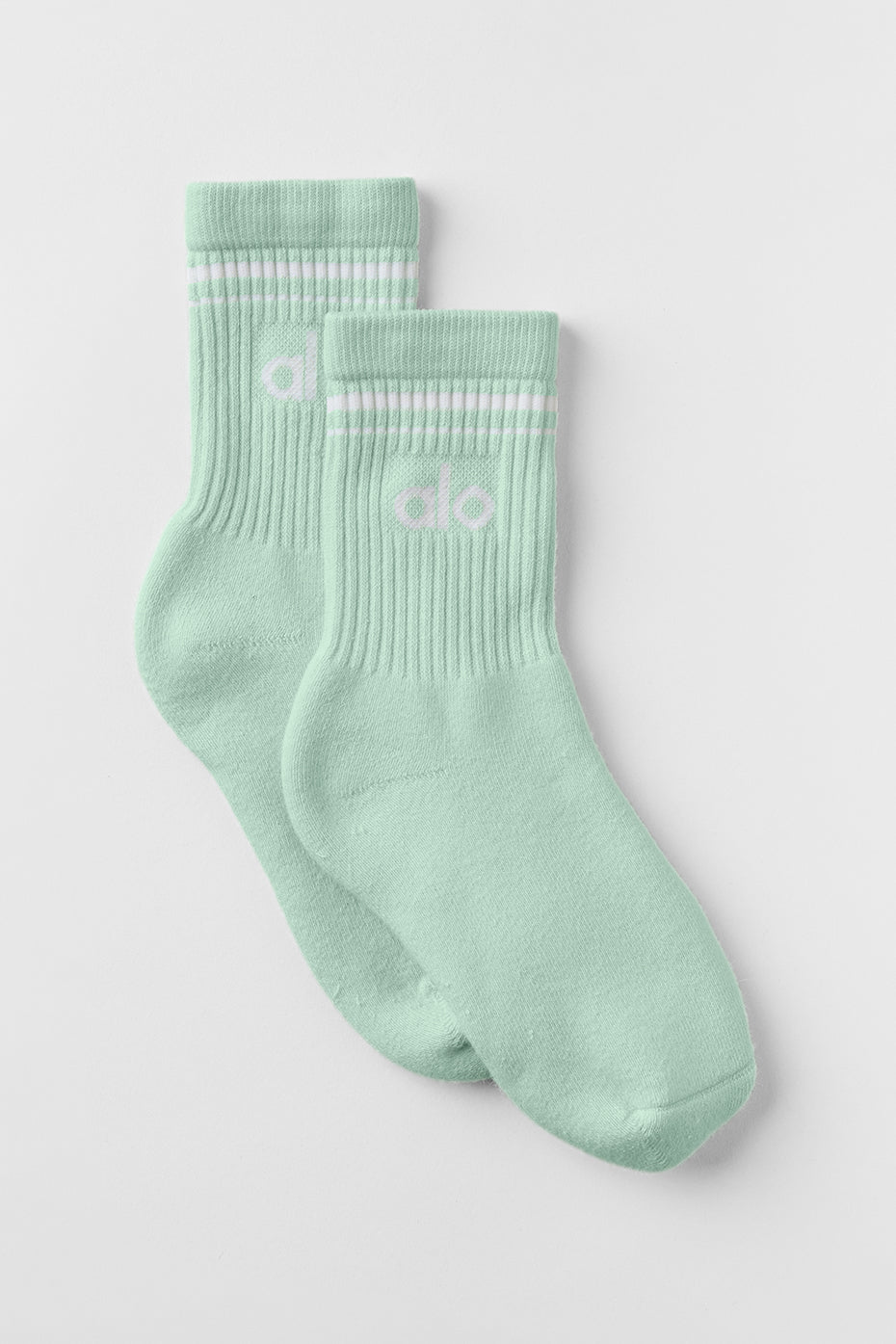Close-up of RetroFlex white crew socks styled with white sneakers on California boardwalk.
