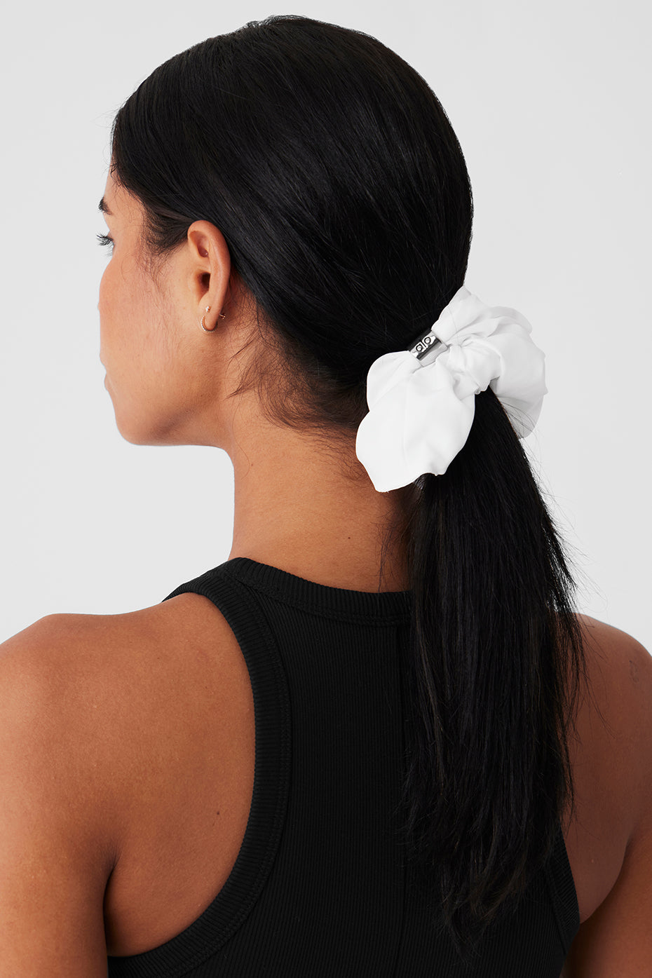 Model styling hair with oversized scrunchie for casual day in New York