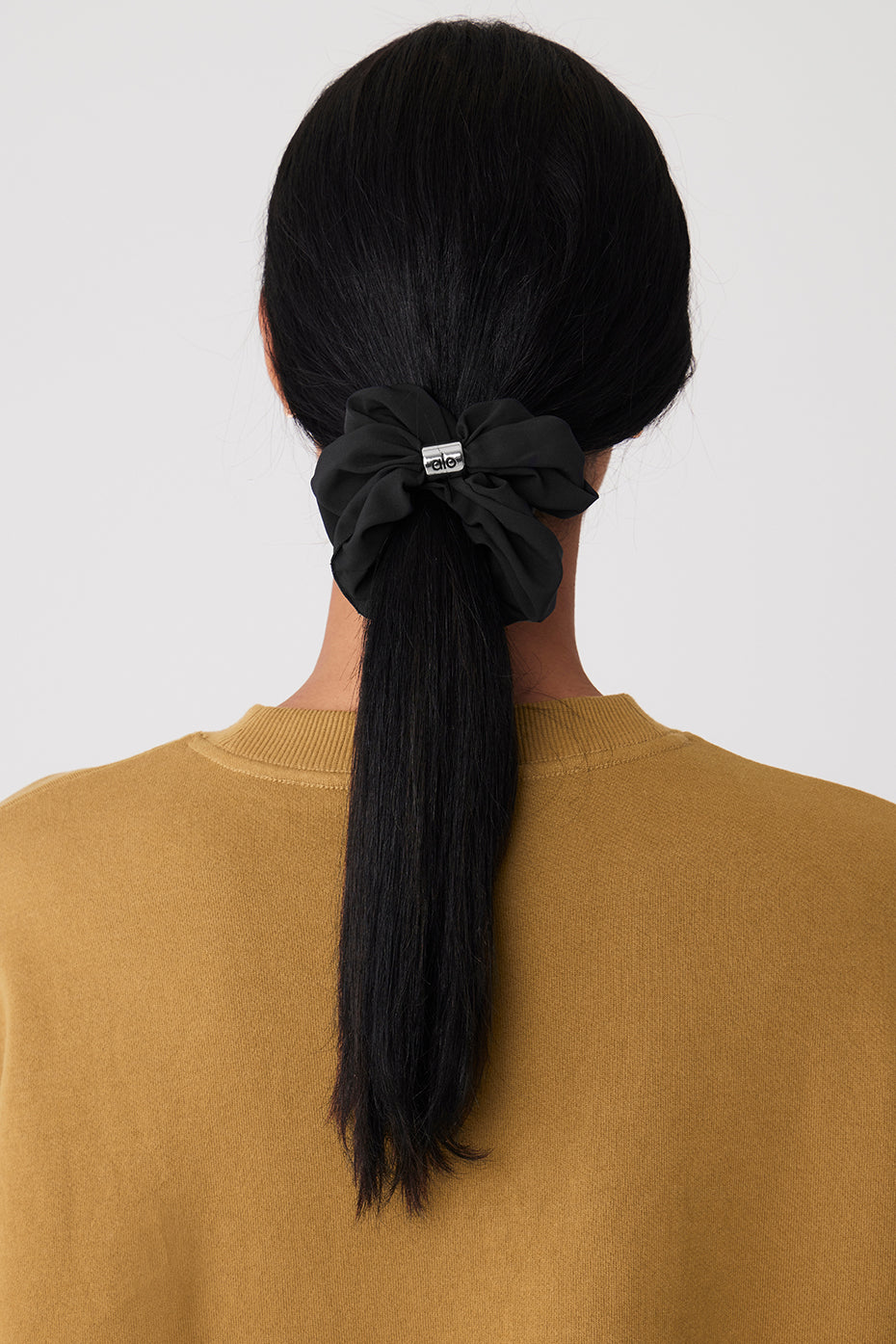 Flat lay of the black velvet scrunchie next to black scrunchie socks.