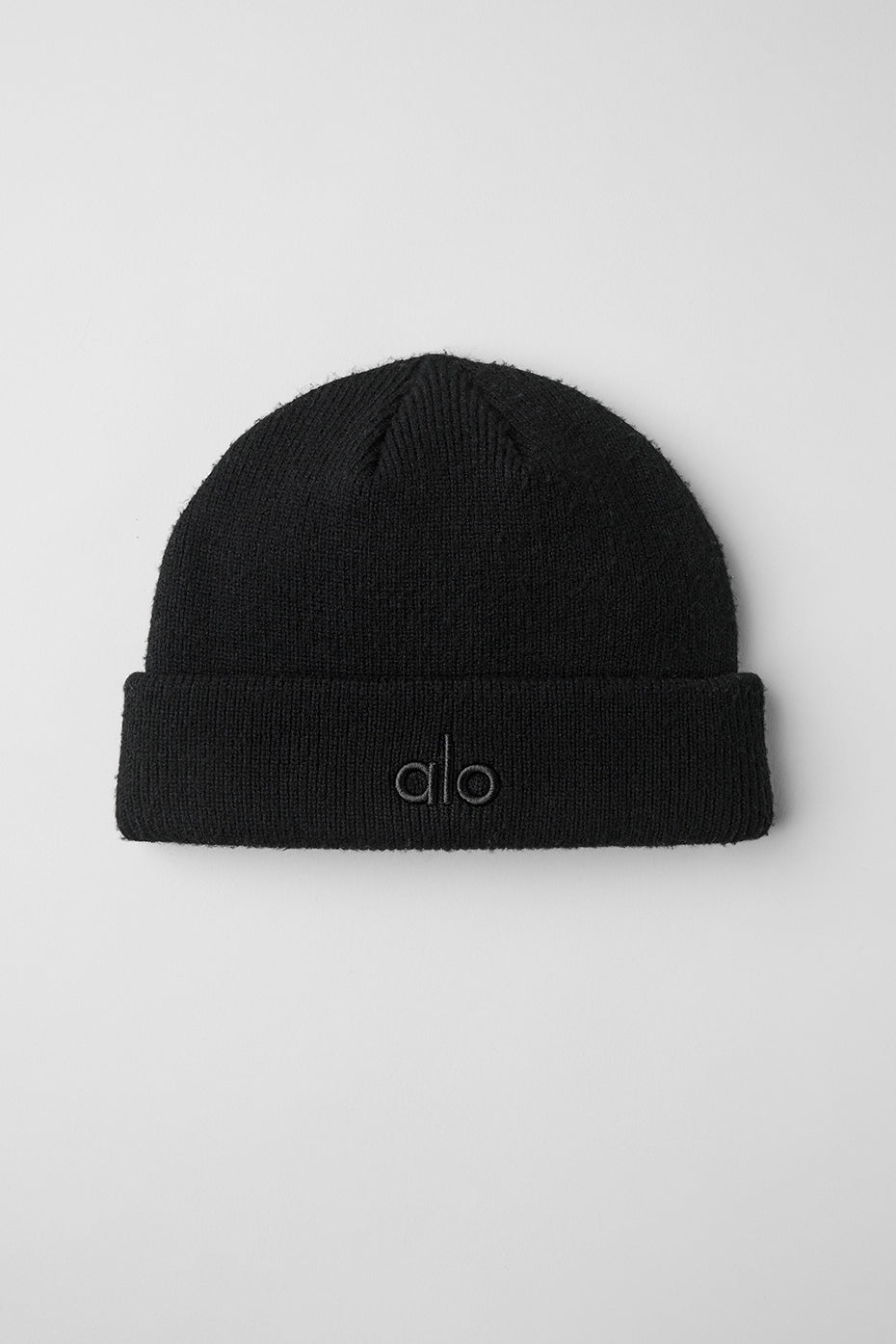 Chic ribbed black beanie worn on a snowy day in the city.