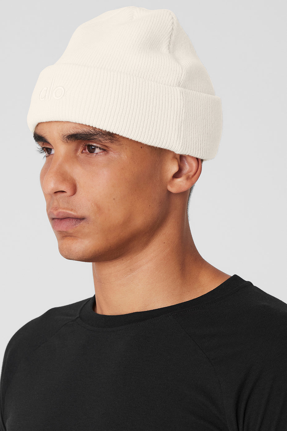 Front view of ivory ribbed beanie on a model outdoors