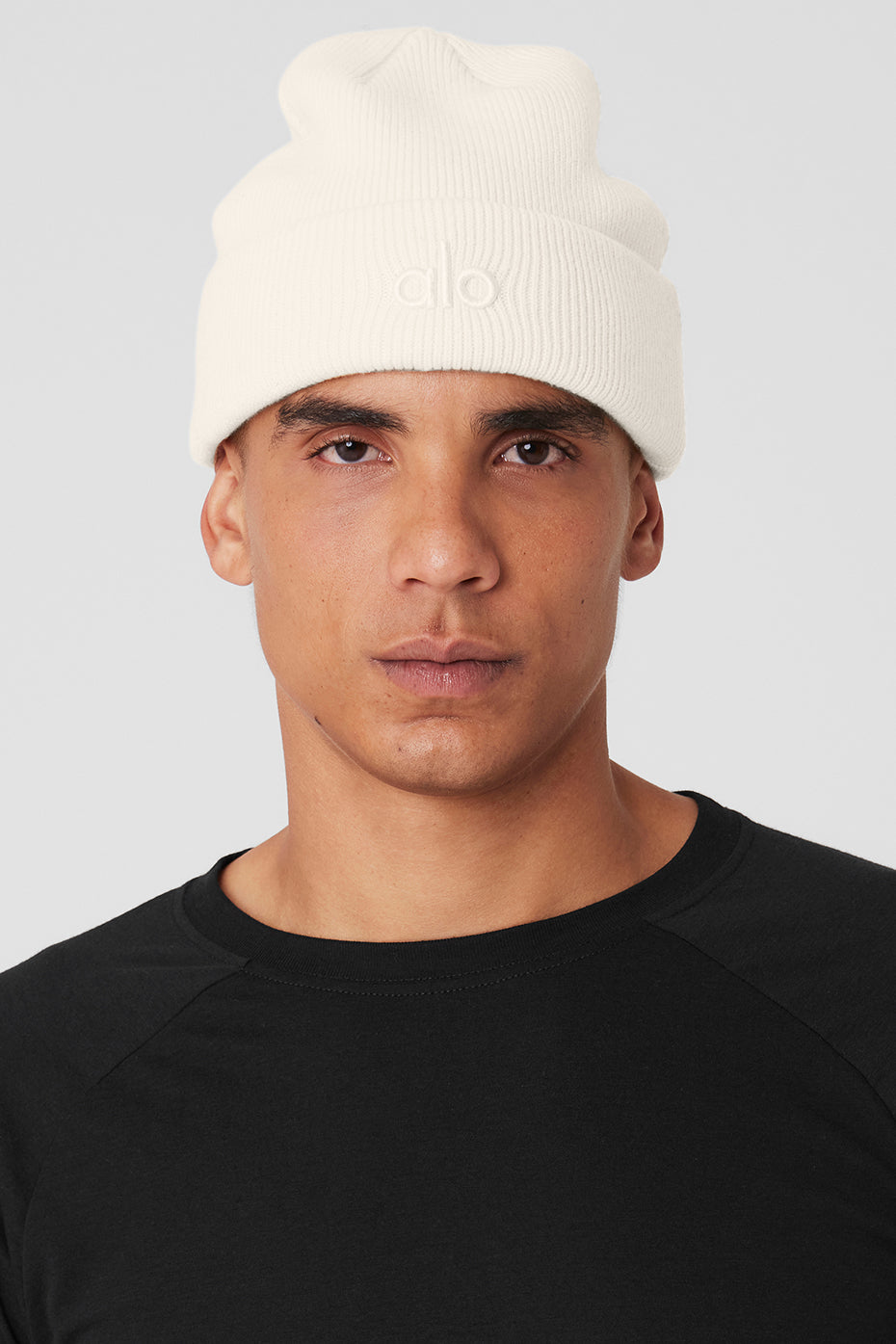 Front view of ivory ribbed beanie on a model outdoors