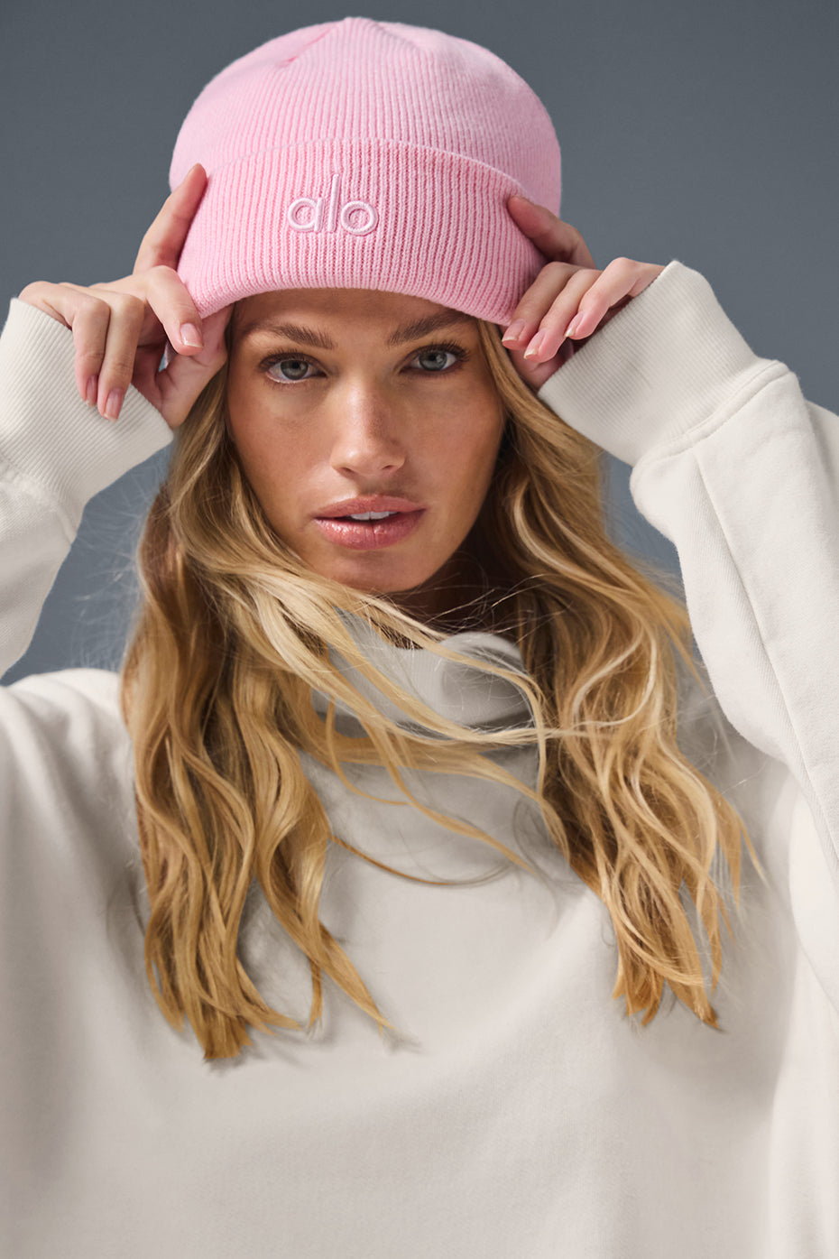 Pink ribbed beanie worn by a person outdoors in winter, highlighting warmth and style