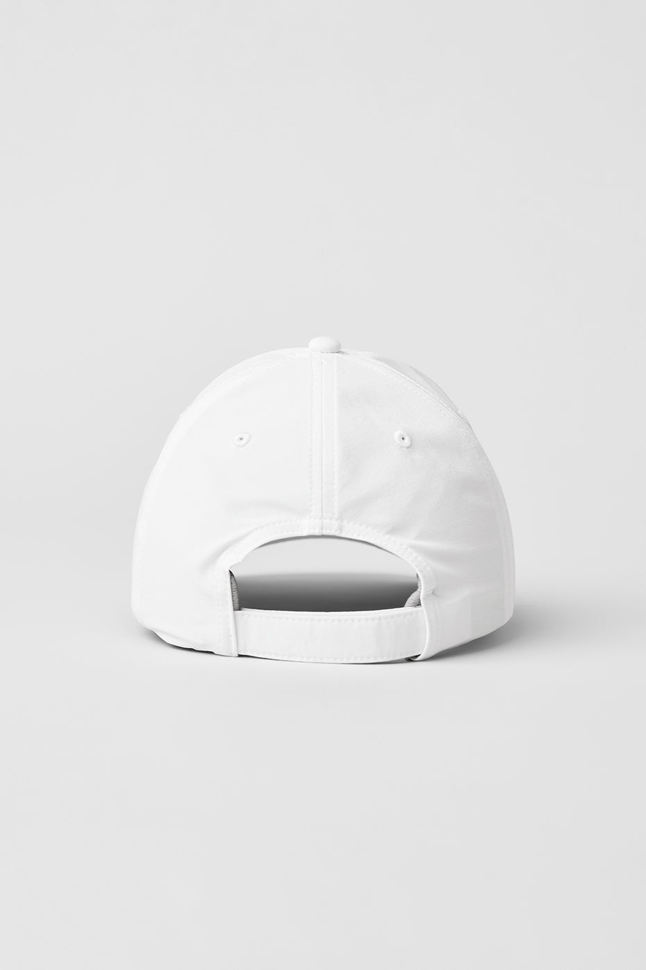 Front view of white baseball cap on a fitness bench near the ocean.
