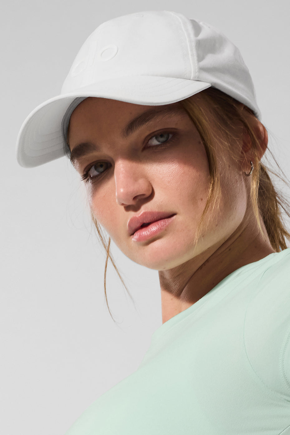 Close-up of velcro strap on performance hat, set beside gym gear.