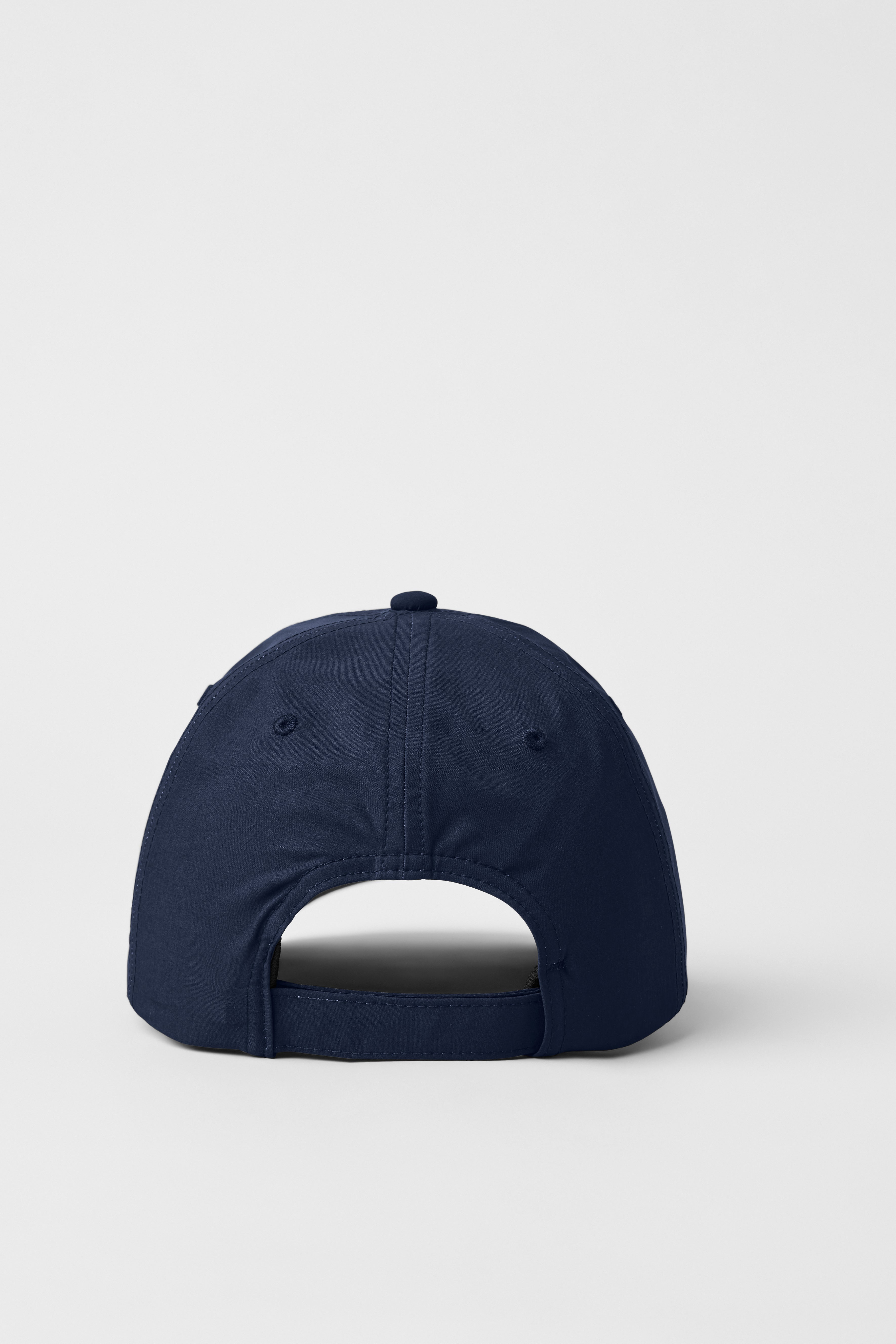 Close-up showing the curved brim of the adjustable baseball cap.