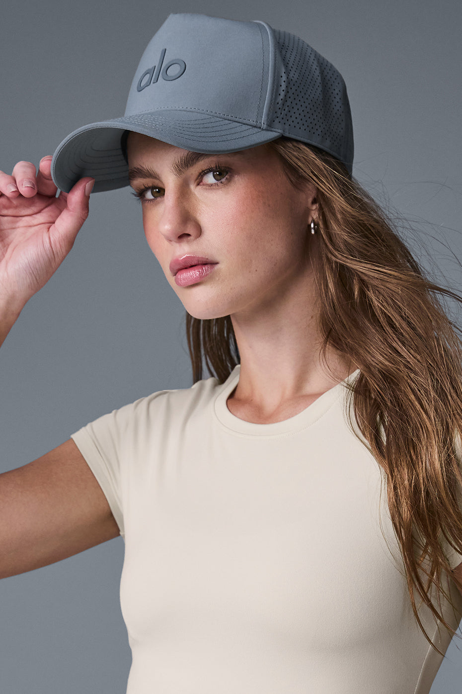 Side angle of the black trucker hat, highlighting the breathable back perforations.