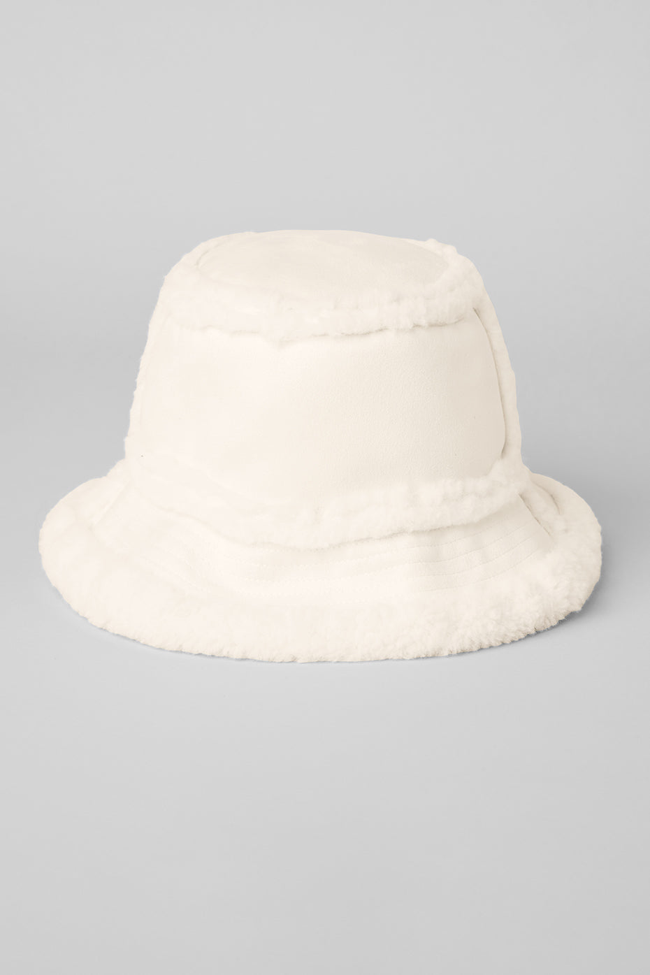 Cozy ivory bucket hat folded for easy packing during winter travels.