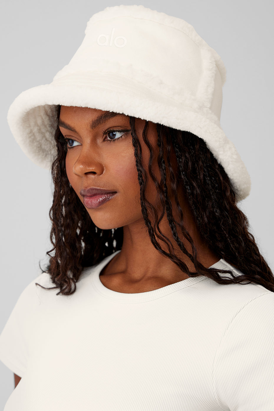 Cozy ivory bucket hat styled with the brim up, ideal for winter fashion.