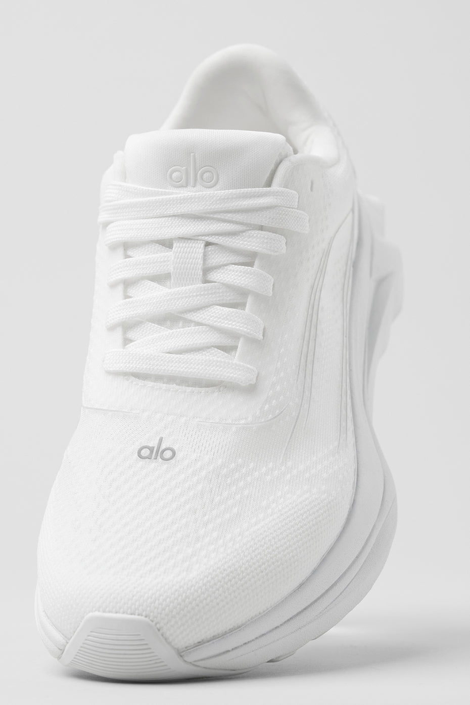 Close-up of ALO Runner shoes showing stability heel clip and breathable mesh upper