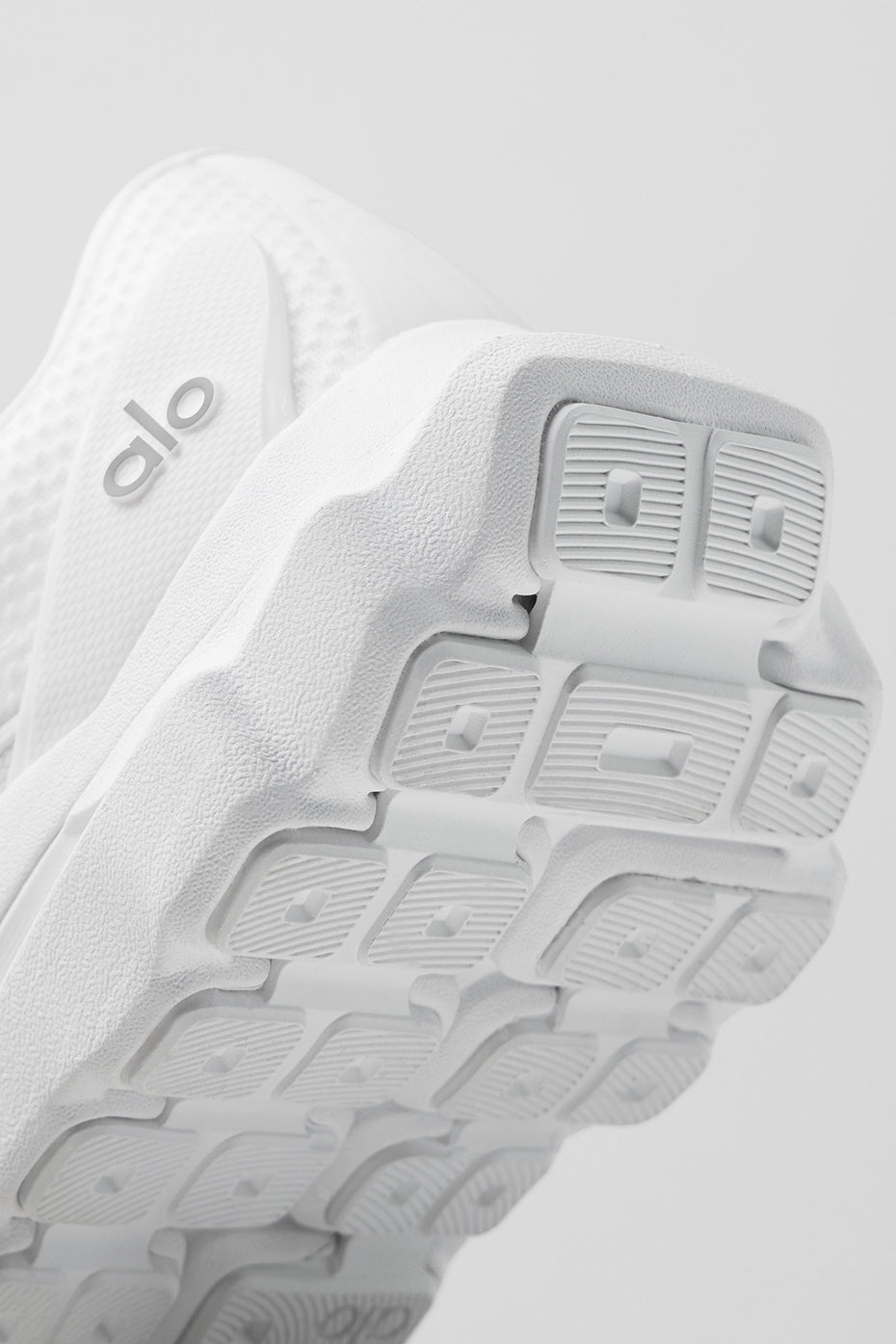 Side view of ALO Runner shoes highlighting dual-density midsole for responsiveness