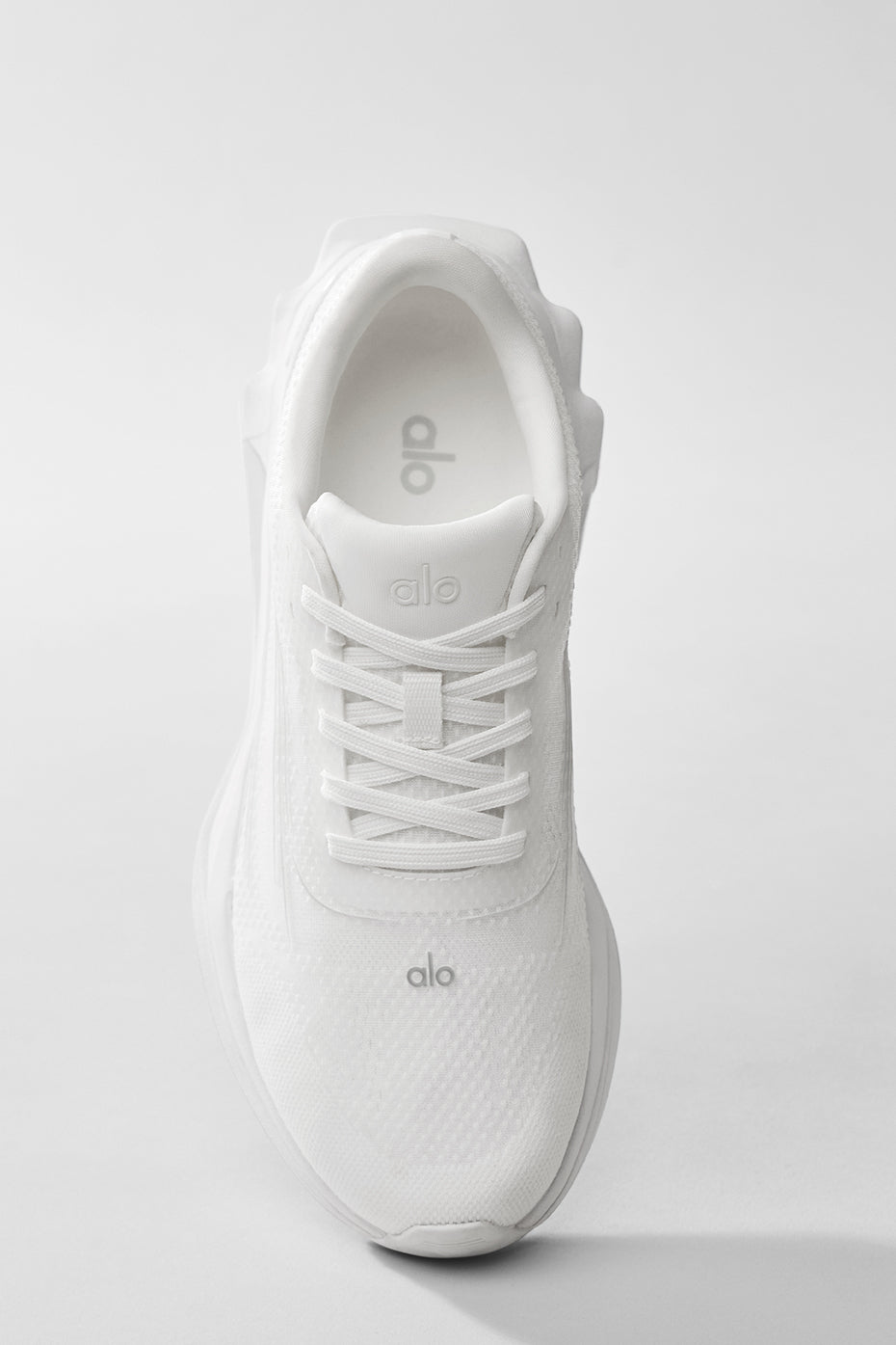 Close-up of ALO Runner shoes showing stability heel clip and breathable mesh upper