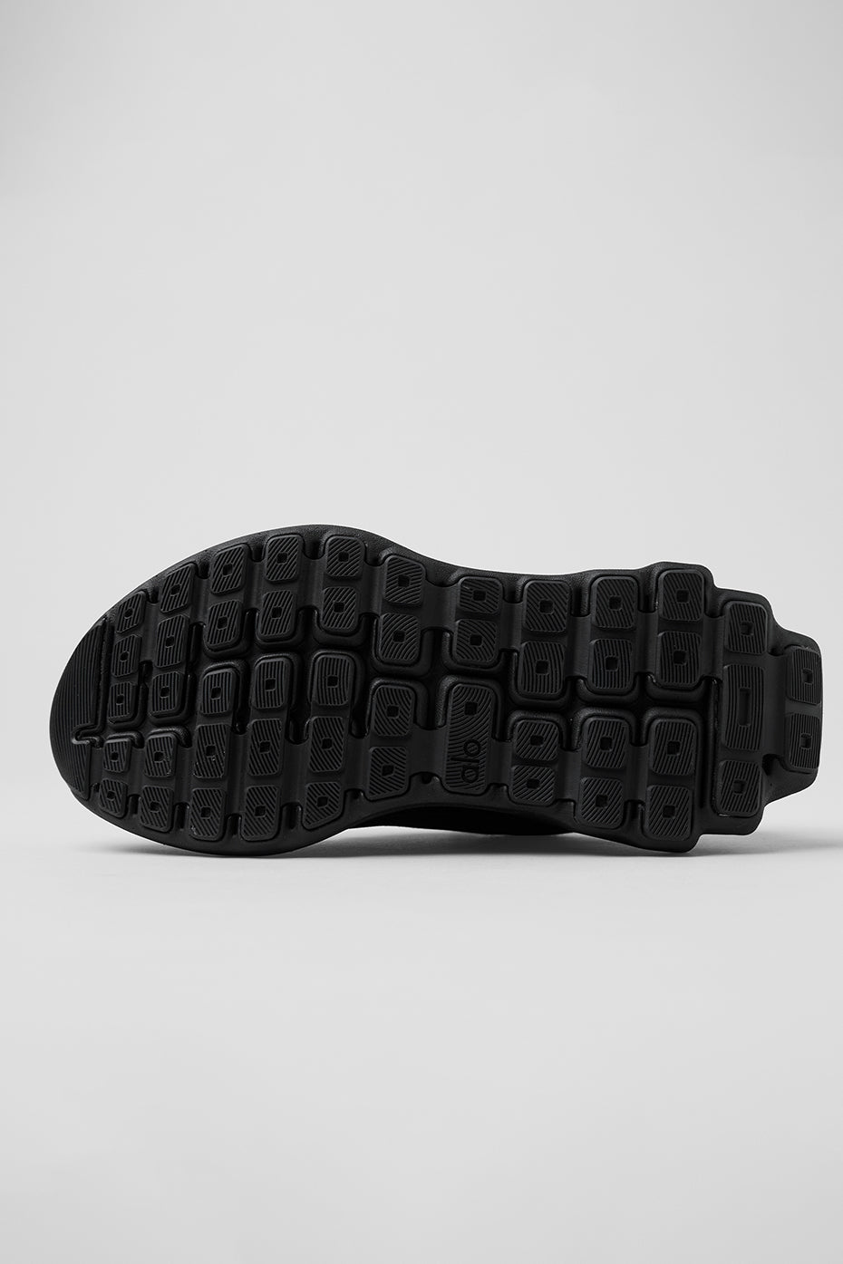 Person wearing ALO Runner shoes jogging on city streets.