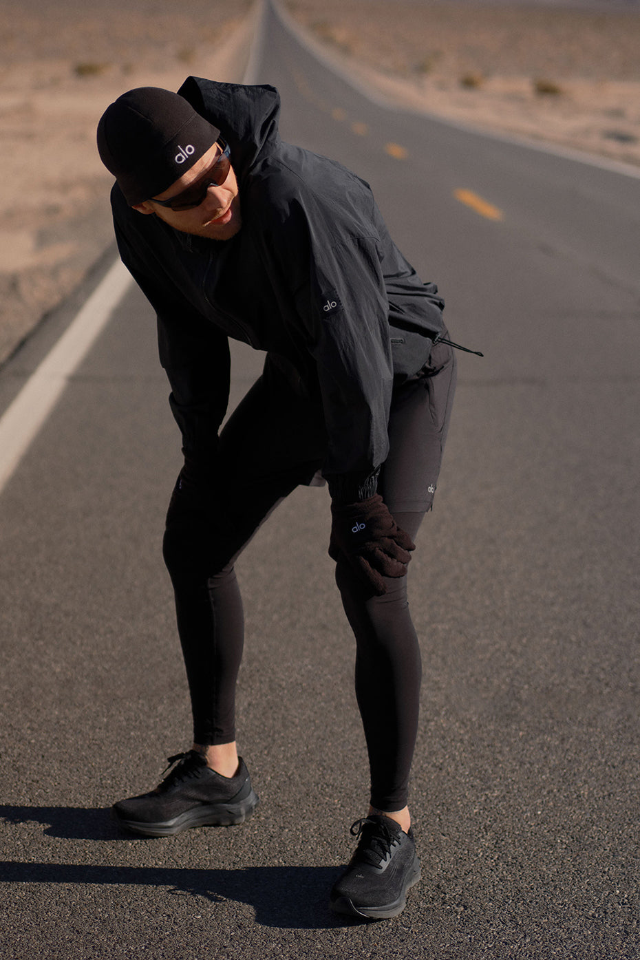 Person wearing ALO Runner shoes jogging on city streets.