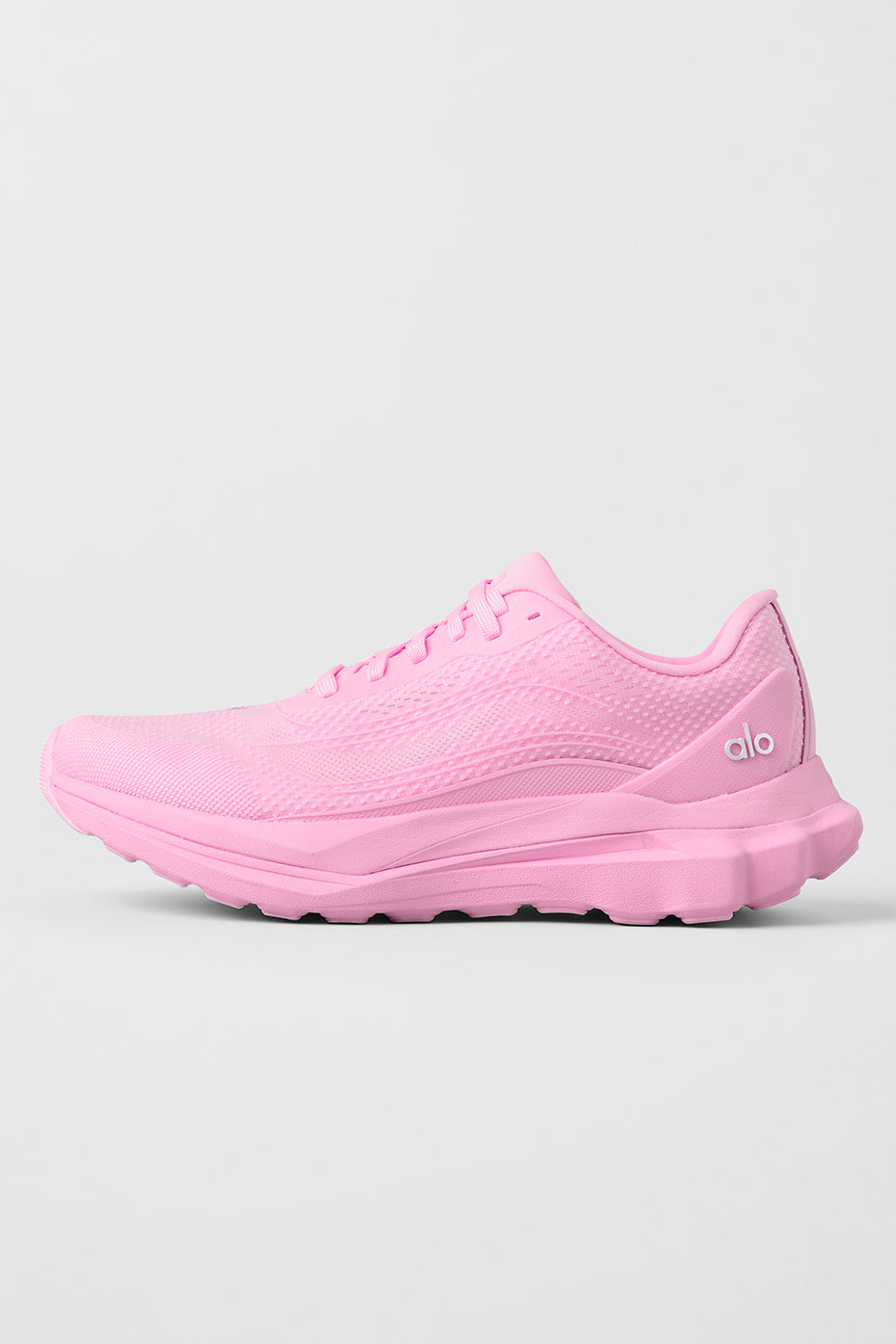Side view of ALO Runner Sweet Pink athletic shoes on a trail