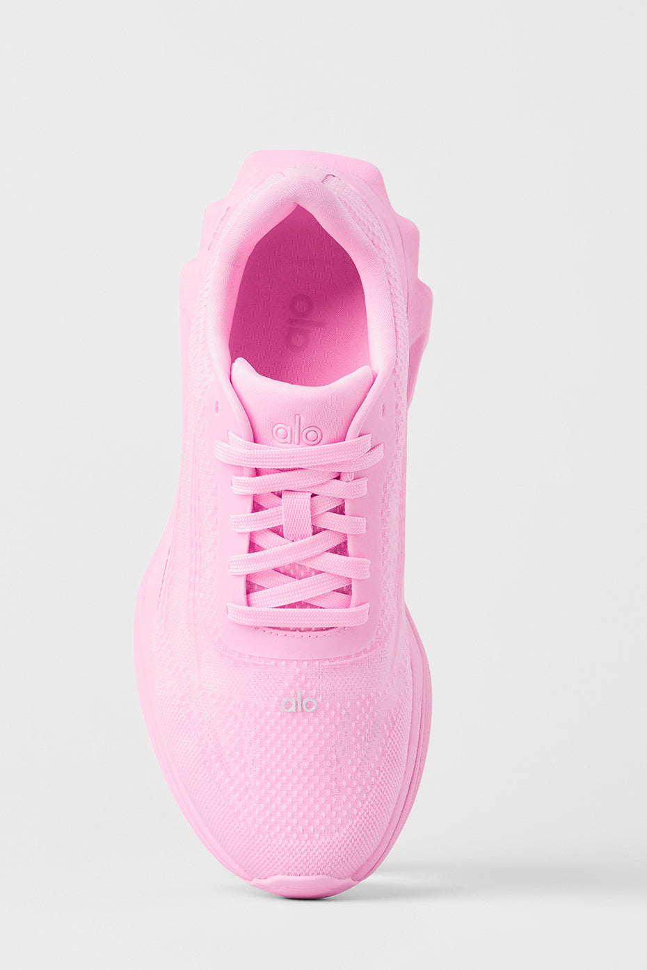 Side view of ALO Runner Sweet Pink athletic shoes on a trail