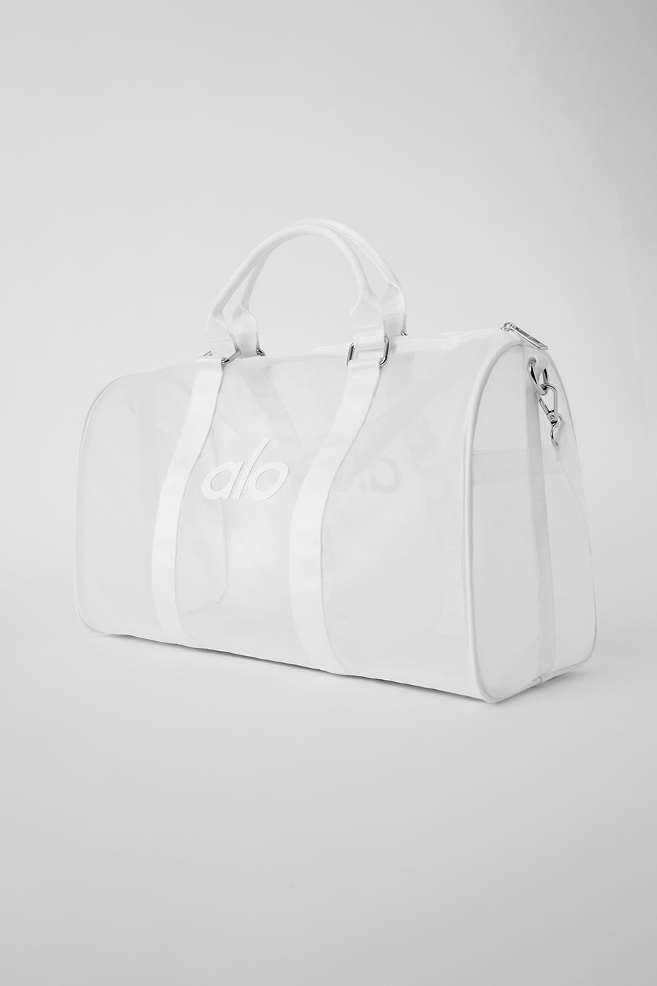 Duffle bag standing on sand at the beach with waves in the background