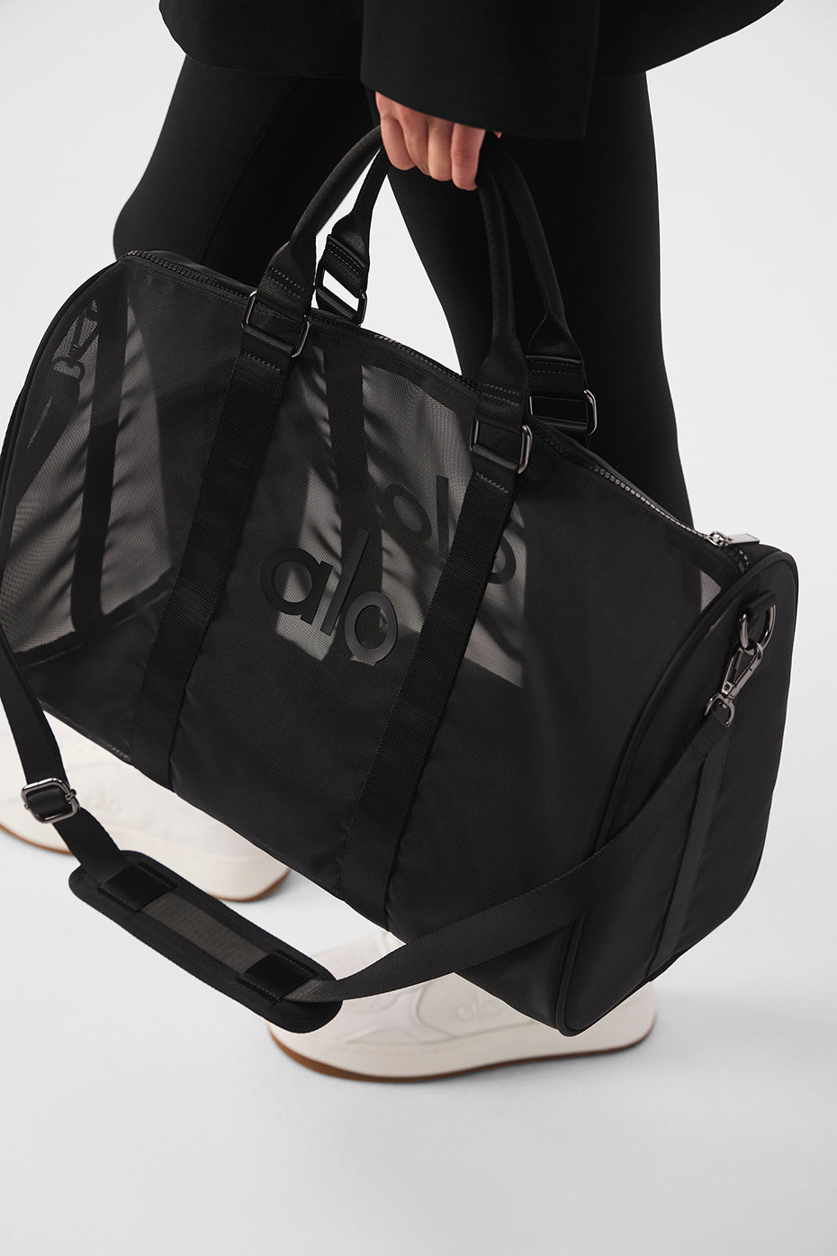 Close-up of the zipper and handles on the black duffle bag.