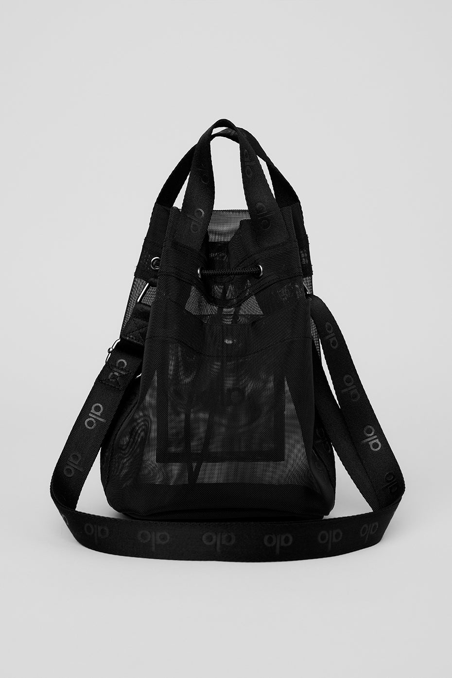 Stylish black mesh crossbody bucket bag shown in a cafe setting, ideal for day-to-night use.