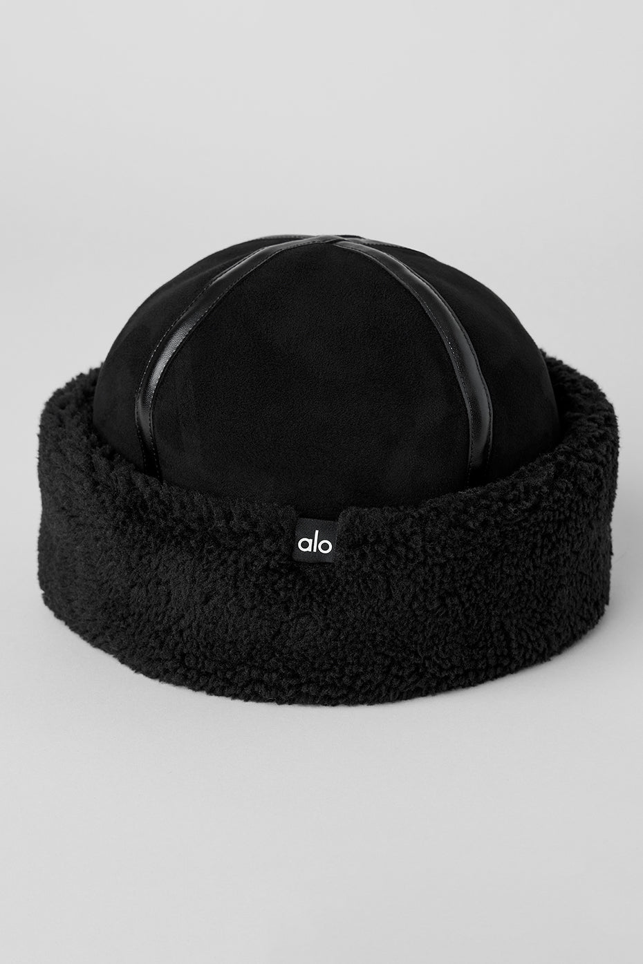 Model wearing the stylish black sherpa hat with a matching jacket in a snowy setting.