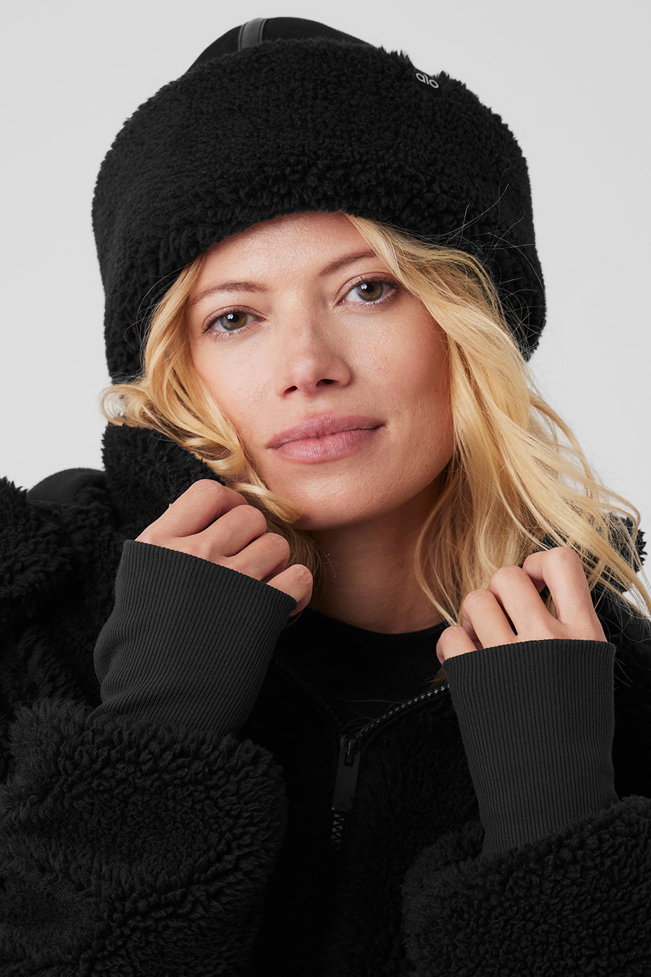 Close-up of the black sherpa winter hat showcasing the plush brim and suede crown.