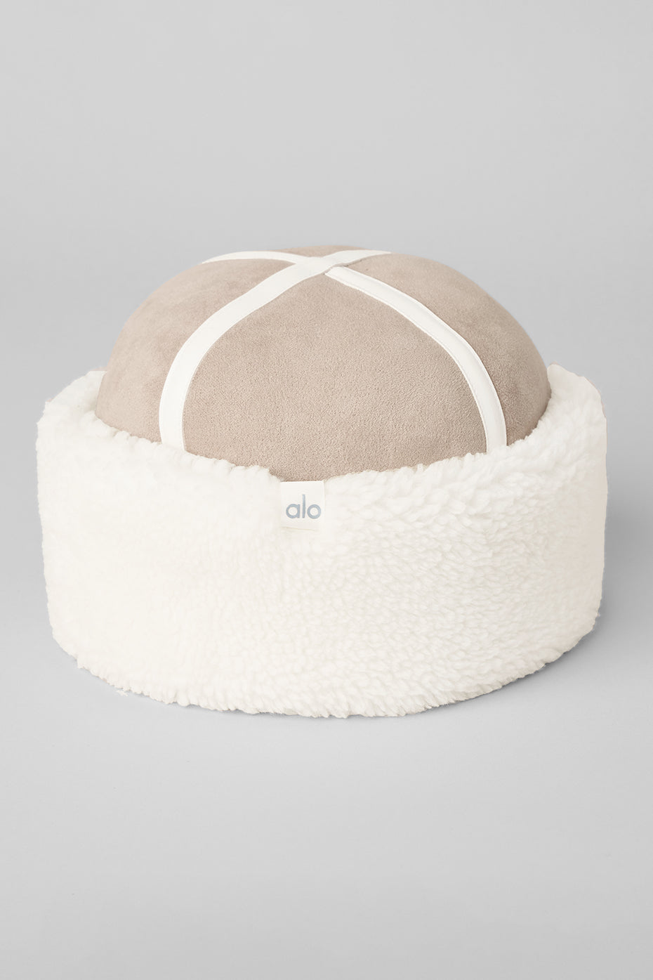 Model wearing sherpa bucket hat with coat on urban sidewalk