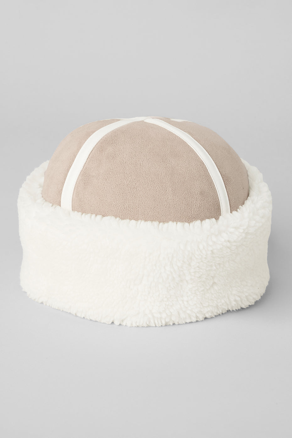Sherpa hat styled with jacket and boots in snowy outdoor setting