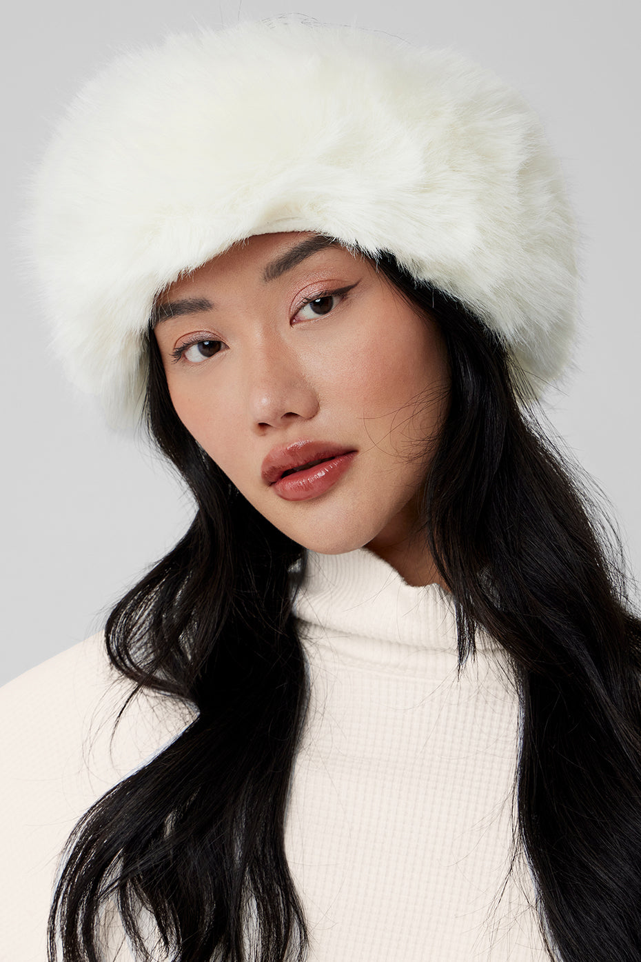 Front view of ivory faux fur headband styled for cold-weather comfort