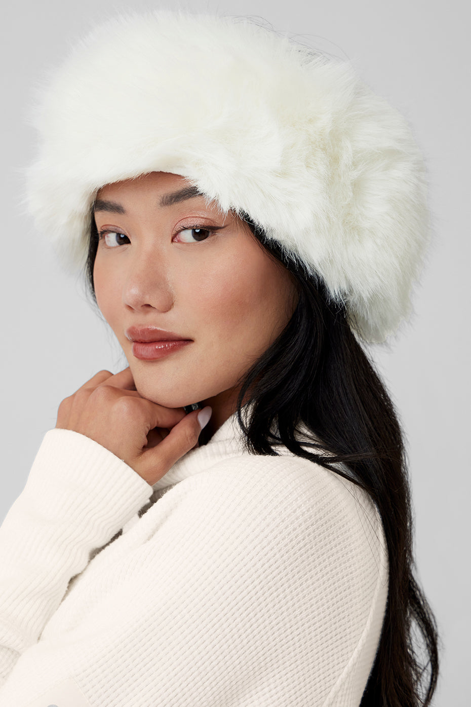 Front view of ivory faux fur headband styled for cold-weather comfort