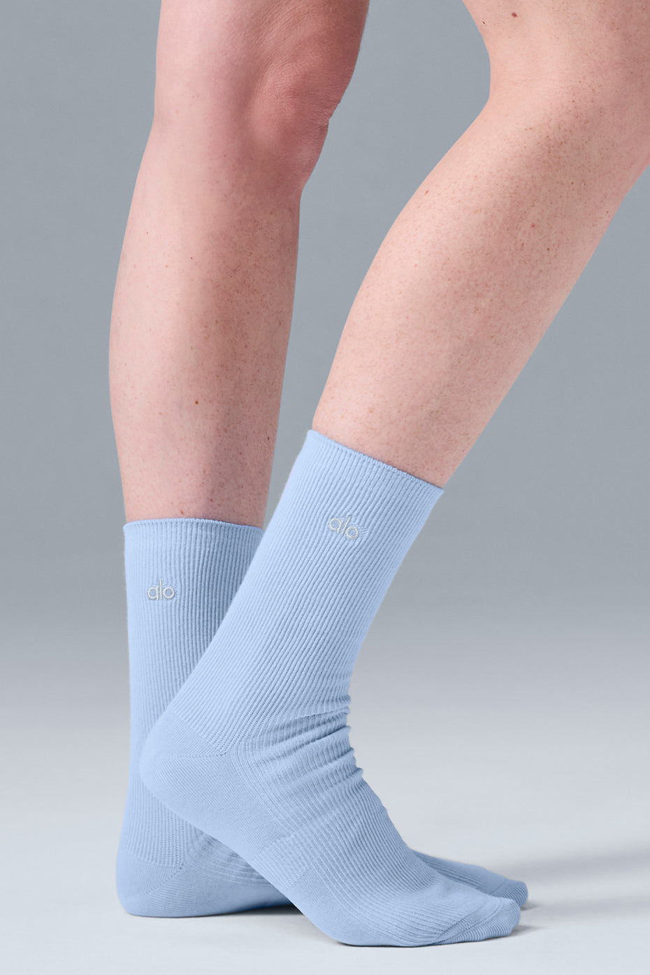 Lifestyle shot of ALO socks worn casually in a cozy setting.