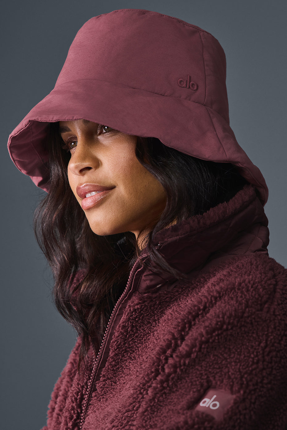 Side view of burgundy bucket hat with wide brim and puff embroidery