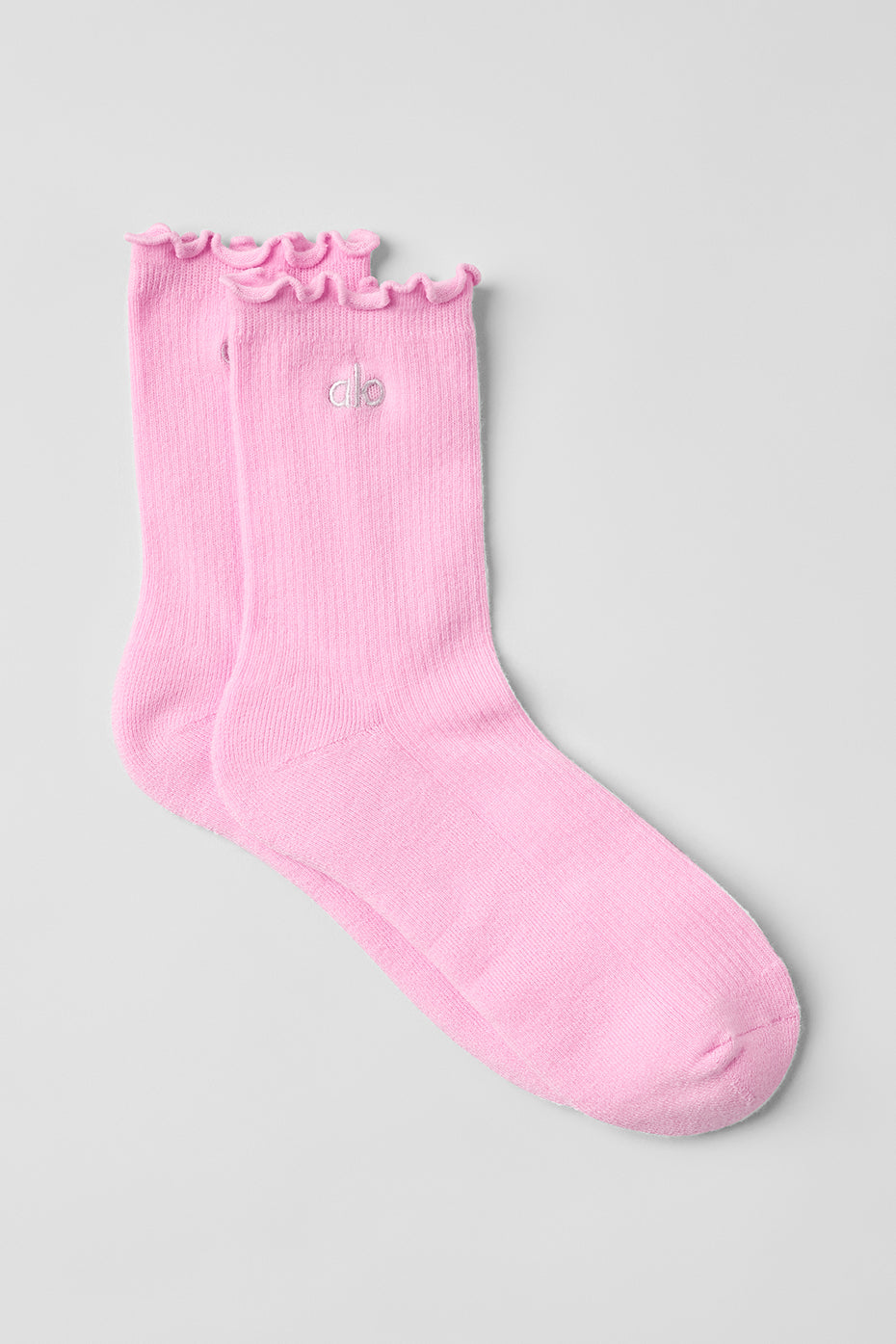 Pink lettuce edge socks with ruffled trim displayed on a flat surface