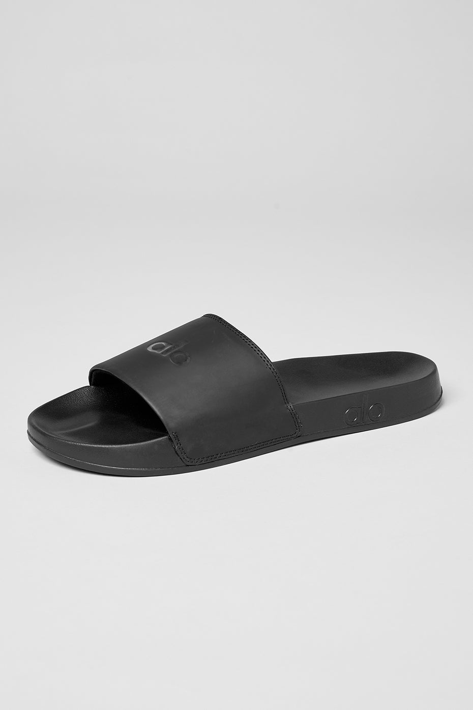 Close-up of black unisex slides showing padded strap and cushioned sole for comfort