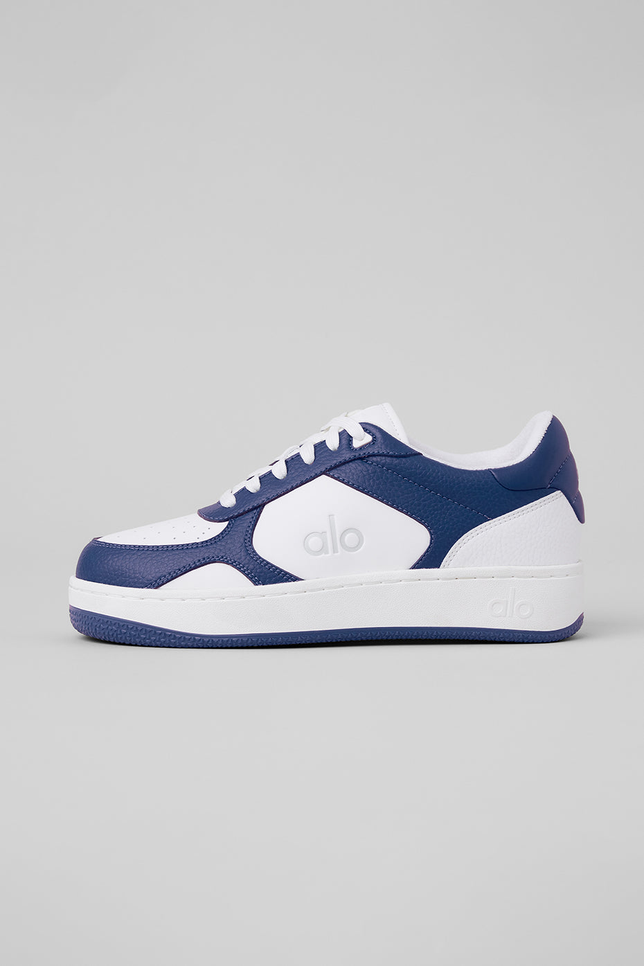 Side view of ALO Recovery Mode Sneakers in Navy and White, showcasing the sleek design.