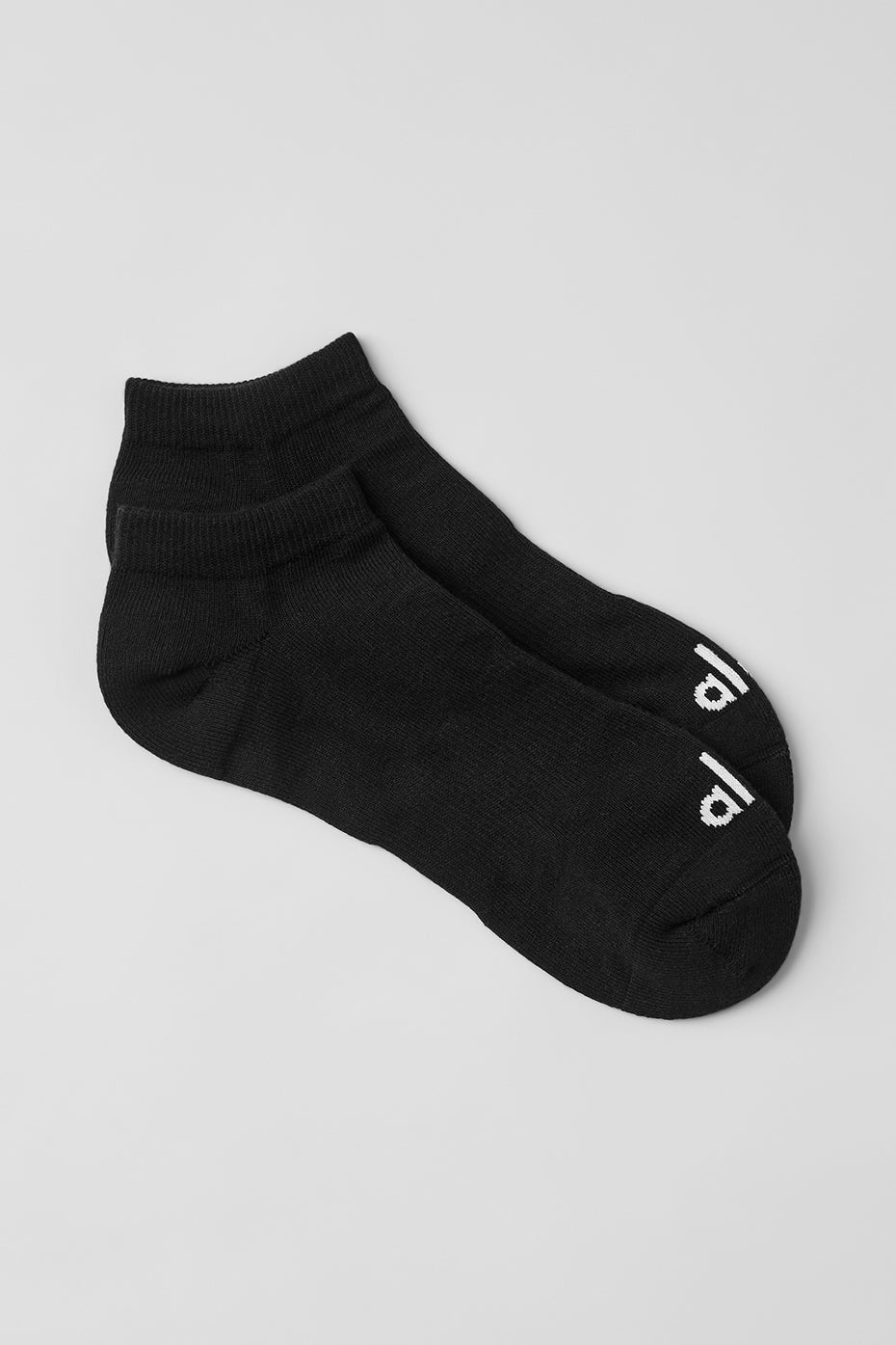 Close-up of black and white striped socks with sneakers on a city street