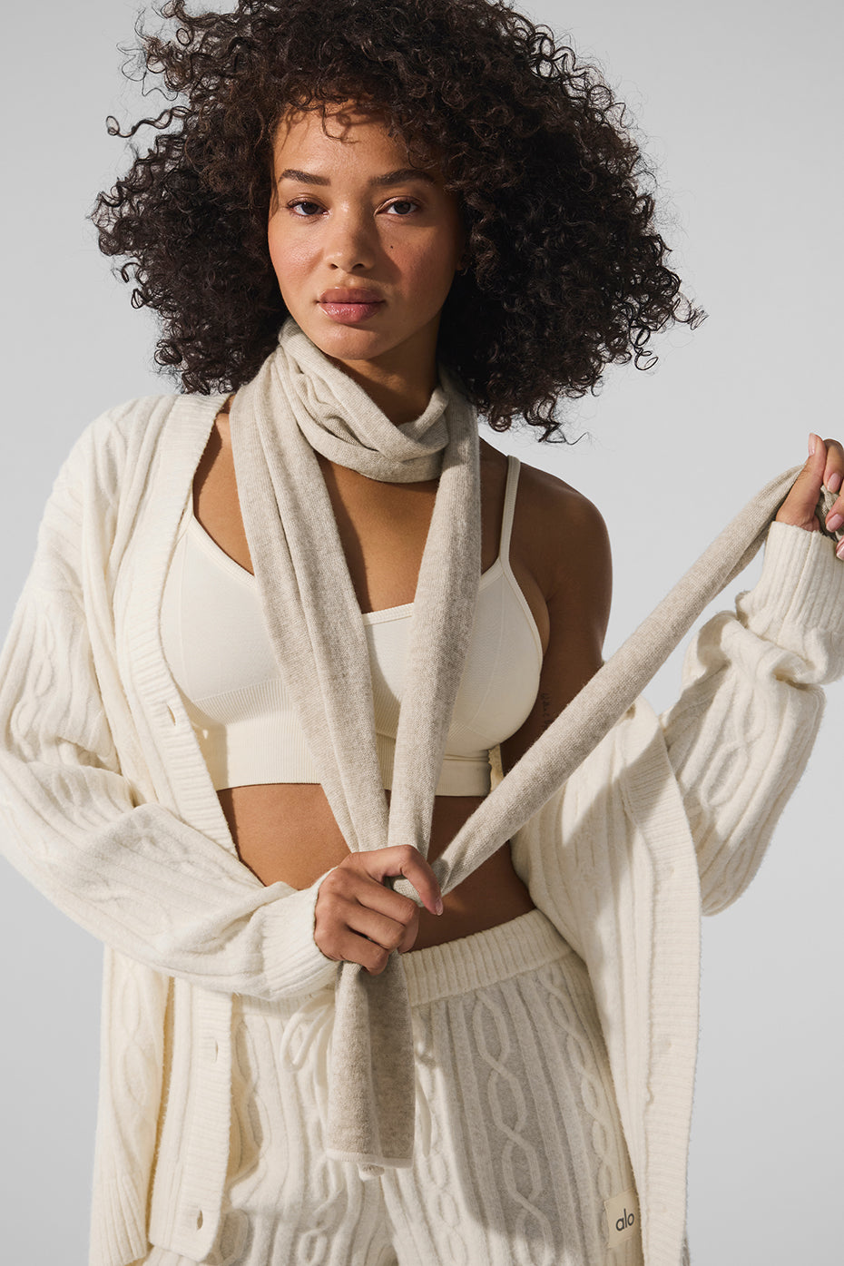 Model wearing men's cashmere scarf in frosted ivory latte, street style angle