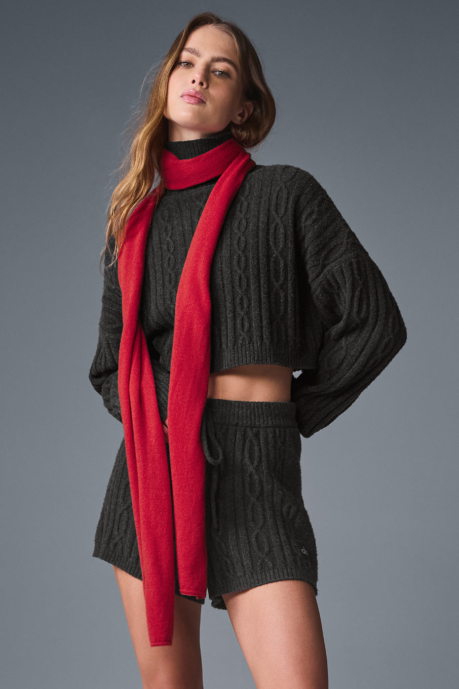 Red cashmere scarf displayed on a wooden table, showcasing its soft texture.