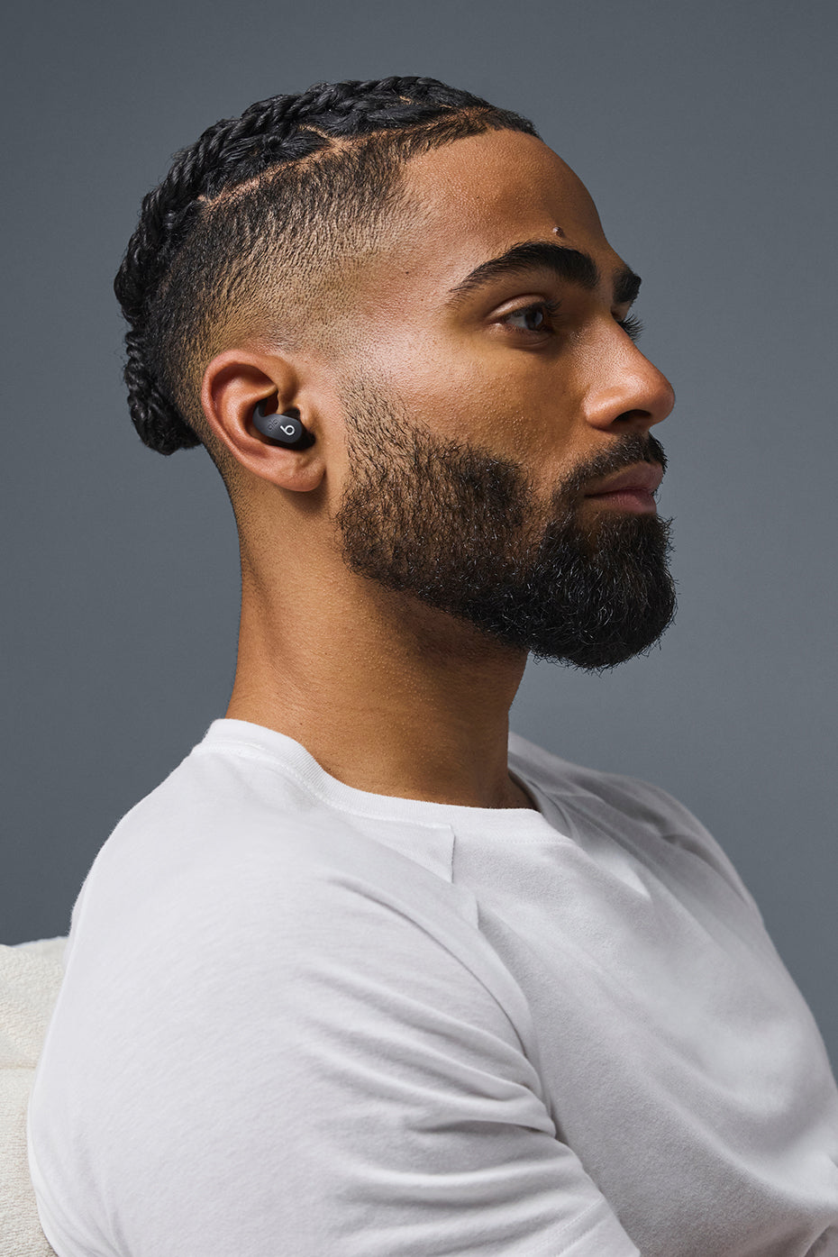 Close-up of wireless earbuds highlighting chrome finish and ergonomic tips