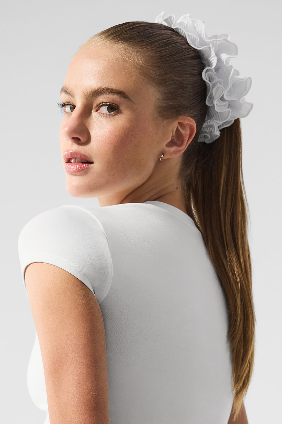 Oversized silk scrunchie styled in a high ponytail for a chic look.