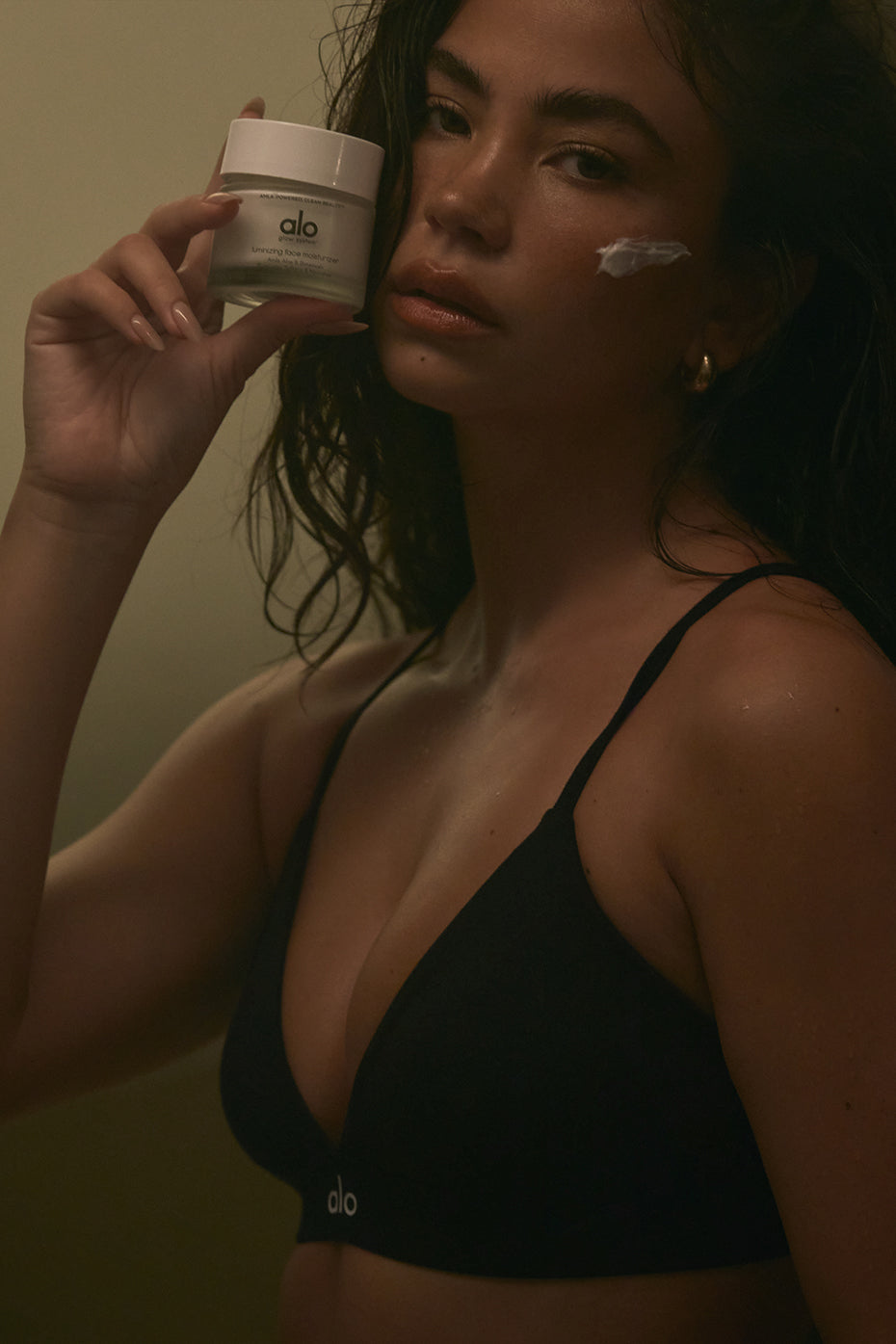 Model applying the hydrating face moisturizer for a luminous look.