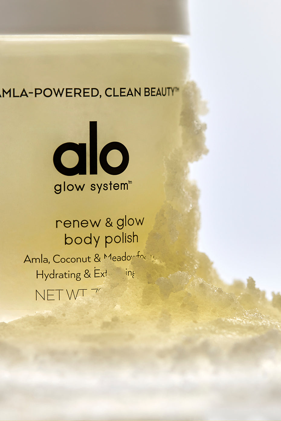 Renew & Glow Body Scrub jar on bathroom shelf with natural light