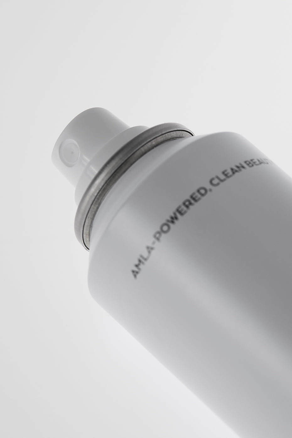 User applying dry shampoo for oil control after workout.